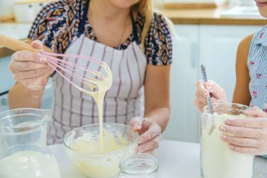 Anne ve çocuk mutfakta hamur işi pişirir. Mutfakta hamuru hazırlar. Seçici odaklanma. İnsanlar.