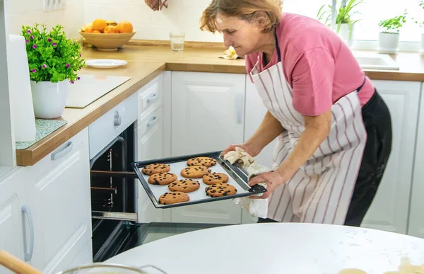 Mutfaktaki yaşlı büyükanne mutfakta hamur işi pişiriyor. Seçici odaklanma. Yiyecek..