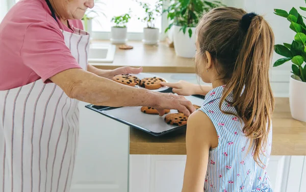 Büyükanne ve torun mutfakta kurabiye pişiriyorlar. Seçici odak.