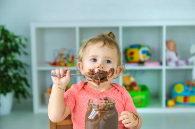 Bebek çok fazla çikolata yiyor. Seçici odaklanma. Çocuk.
