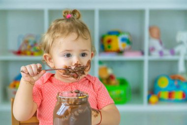 Bebek çok fazla çikolata yiyor. Seçici odaklanma. Çocuk.