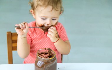 Bebek çok fazla çikolata yiyor. Seçici odaklanma. Çocuk.