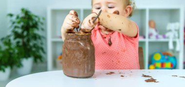 Bebek çok fazla çikolata yiyor. Seçici odaklanma. Çocuk.