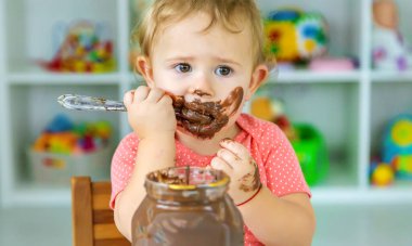 Bebek çok fazla çikolata yiyor. Seçici odaklanma. Çocuk.