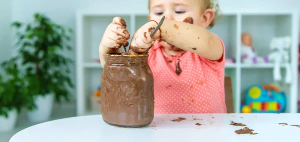 赤ん坊はチョコレートのお菓子をたくさん食べる 選択的フォーカス — ストック写真