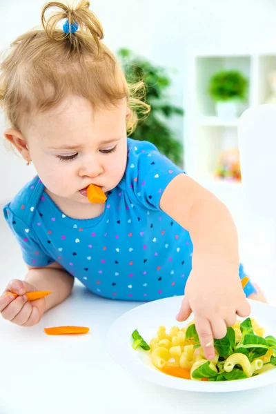 子供の赤ん坊は野菜とパスタを食べる 選択的フォーカス 食べ物 — ストック写真