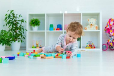 Bir bebek çocuk oyun odasında oyuncaklarla oynar. Seçici odaklanma. Çocuk.