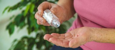 Yaşlı bir kadın elinde haplar tutuyor. Seçici odaklanma. Peopel.