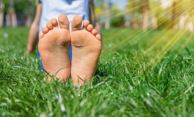 Çimlerin üzerinde çocuk ayakları. Seçici odaklanma. Doğa.