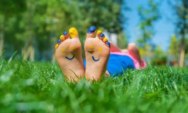 Ukrayna bayrağı üzerinde çocuk ayakları. Seçici odaklanma. Doğa.