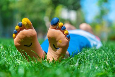 Ukrayna bayrağı üzerinde çocuk ayakları. Seçici odak.