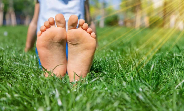 Çimlerin üzerinde çocuk ayakları. Seçici odaklanma. Doğa.