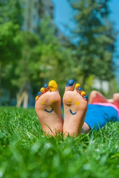 Ukrayna bayrağı üzerinde çocuk ayakları. Seçici odaklanma. Doğa.