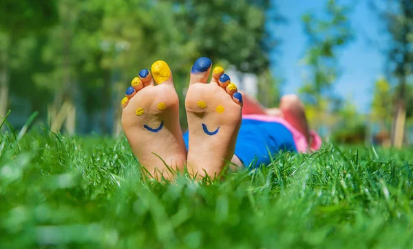 Ukrayna bayrağı üzerinde çocuk ayakları. Seçici odaklanma. Doğa.