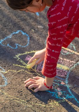 Çocuklar kaldırıma tebeşirli bir ev çizerler. Seçici odak.
