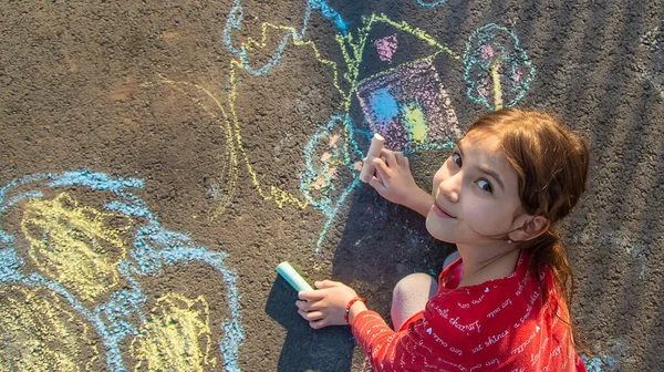 Les enfants dessinent une maison avec de la craie sur le trottoir. Concentration sélective. — Photo
