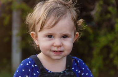 Baby plays snot in the street with a cold nose. Selective focus. Child.