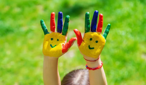 Ręce Dziecka Pomalowanym Uśmiechem Wybiórcze Skupienie Ręce — Zdjęcie stockowe