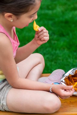 Çocuk parkta cips yiyor. Seçici odaklanma. Çocuk.
