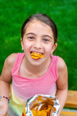 Çocuk parkta cips yiyor. Seçici odaklanma. Çocuk.