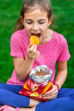 Çocuk parkta cips yiyor. Seçici odaklanma. Çocuk.
