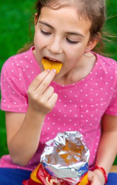Çocuk parkta cips yiyor. Seçici odaklanma. Çocuk.