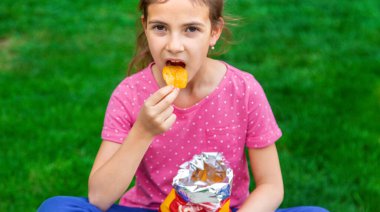 Çocuk parkta cips yiyor. Seçici odaklanma. Çocuk.