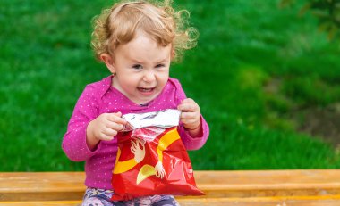 Çocuk parkta cips yiyor. Seçici odaklanma. Çocuk.