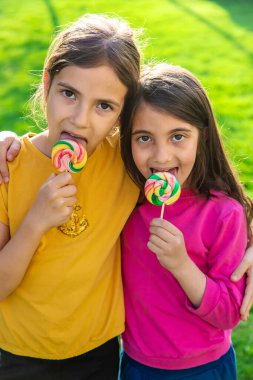 Bir çocuk parkta bir lolipop yiyor. Seçici odaklanma. Kd.