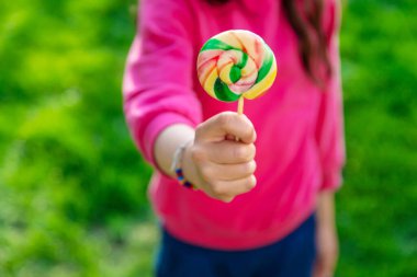 Bir çocuk parkta bir lolipop yiyor. Seçici odaklanma. Kd.