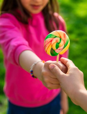 Bir çocuk parkta bir lolipop yiyor. Seçici odaklanma. Kd.