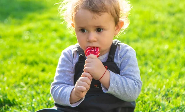 Niño Come Una Piruleta Parque Enfoque Selectivo —  Fotos de Stock