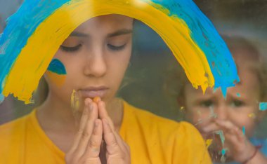 Penceredeki çocuklar gökkuşağı Ukrayna 'nın barışçıl gökyüzünü resmettiler. Seçici odaklanma. Çocuk.