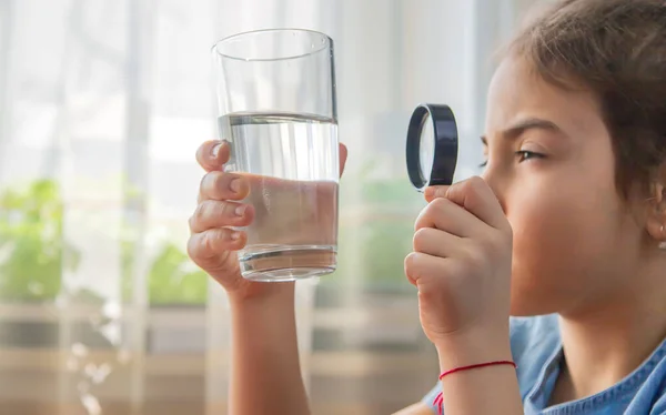 Barnet Undersöker Vattnet Med Ett Förstoringsglas Ett Glas Selektivt Fokus — Stockfoto