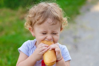 Bir çocuk parkta ekmek yer. Seçici odaklanma. çocuk.