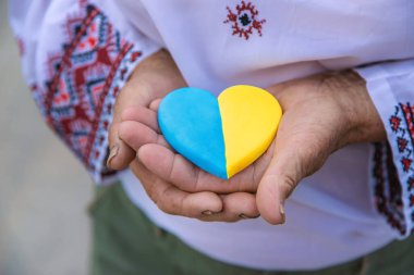 Büyükannem elinde Ukrayna bayrağı renginde bir kalp tutuyor. Seçici odaklanma. İnsanlar.