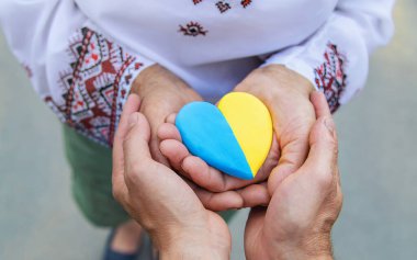 Büyükannem elinde Ukrayna bayrağı renginde bir kalp tutuyor. Seçici odaklanma. İnsanlar.