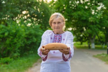 Elinde Ukrayna ekmeği olan bir büyükanne. Seçici odaklanma. Yiyecek..