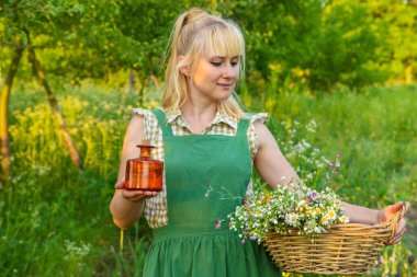 Bir kadın bitkisel tentür üretiyor. Seçici odaklanma. Doğa.