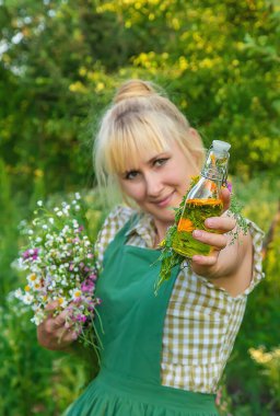 Bir kadın bitkisel tentür üretiyor. Seçici odaklanma. Doğa.