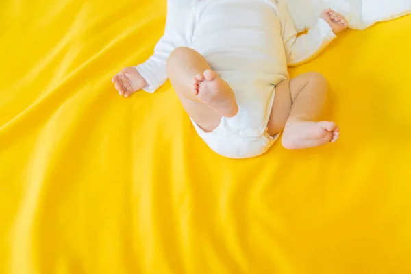 Baby feet on a yellow background. Selective focus. People. Merry Christmas and Happy New Year, Holidays greeting card background. Selective focus.