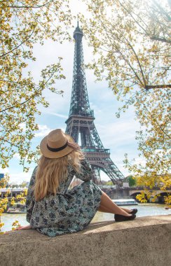 Woman in a hat near the eiffel tower. Selective focus. People.