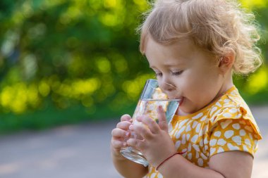 Çocuk bardaktan su içiyor. Seçici odaklanma. Çocuk.