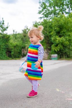 Çocuk kaldırıma tebeşirle çiziyor. Seçici odaklanma. Çocuk.