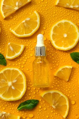 Bottle of cosmetics and drops of liquid, moisturizing lemon. Hyaluronic acid. Selective focus. Spa.