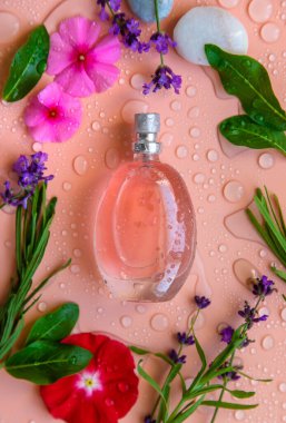 Parfümlü su damlaları ve çiçeklerle dolu bir arka plan. Seçici odaklanma. Spa.