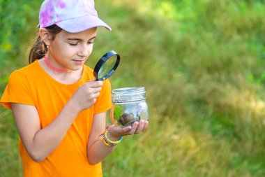 Çocuk salyangoza bakıyor. Seçici odaklanma. Hayvan..