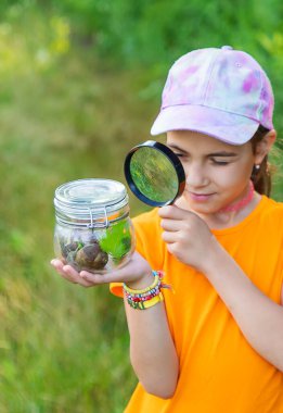 Çocuk salyangoza bakıyor. Seçici odaklanma. Hayvan..