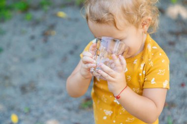 Çocuk bardaktan su içiyor. Seçici odaklanma. Çocuk.