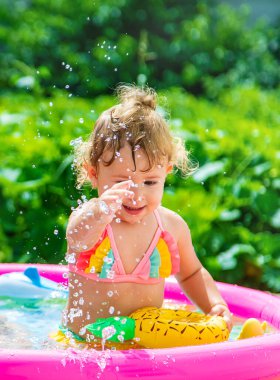 Çocuklar havuzda yüzer. Seçici odaklanma. Çocuk.